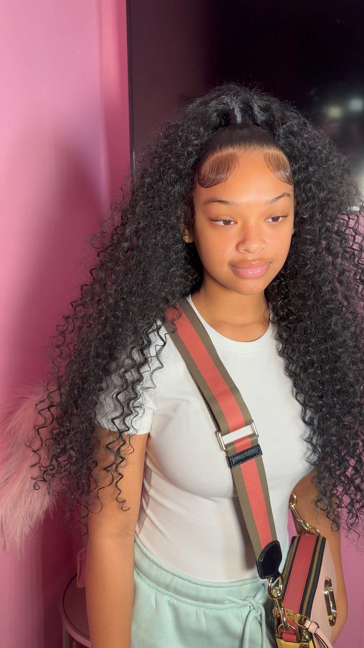 Young woman with long, dark, tightly curled hair in a high ponytail