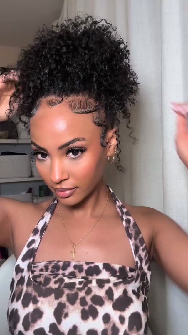 Woman wearing high gathered curls with sleek edges and a leopard-print halter top