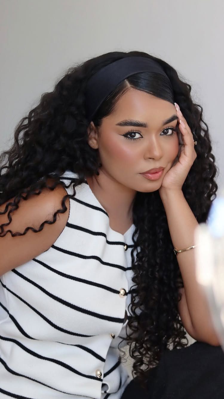 Woman with sleek center-parted hair and long natural curls