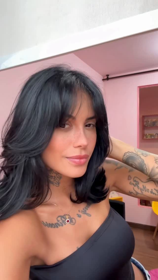 Woman showcasing long dark hair with center-parted curtain bangs and face-framing layers
