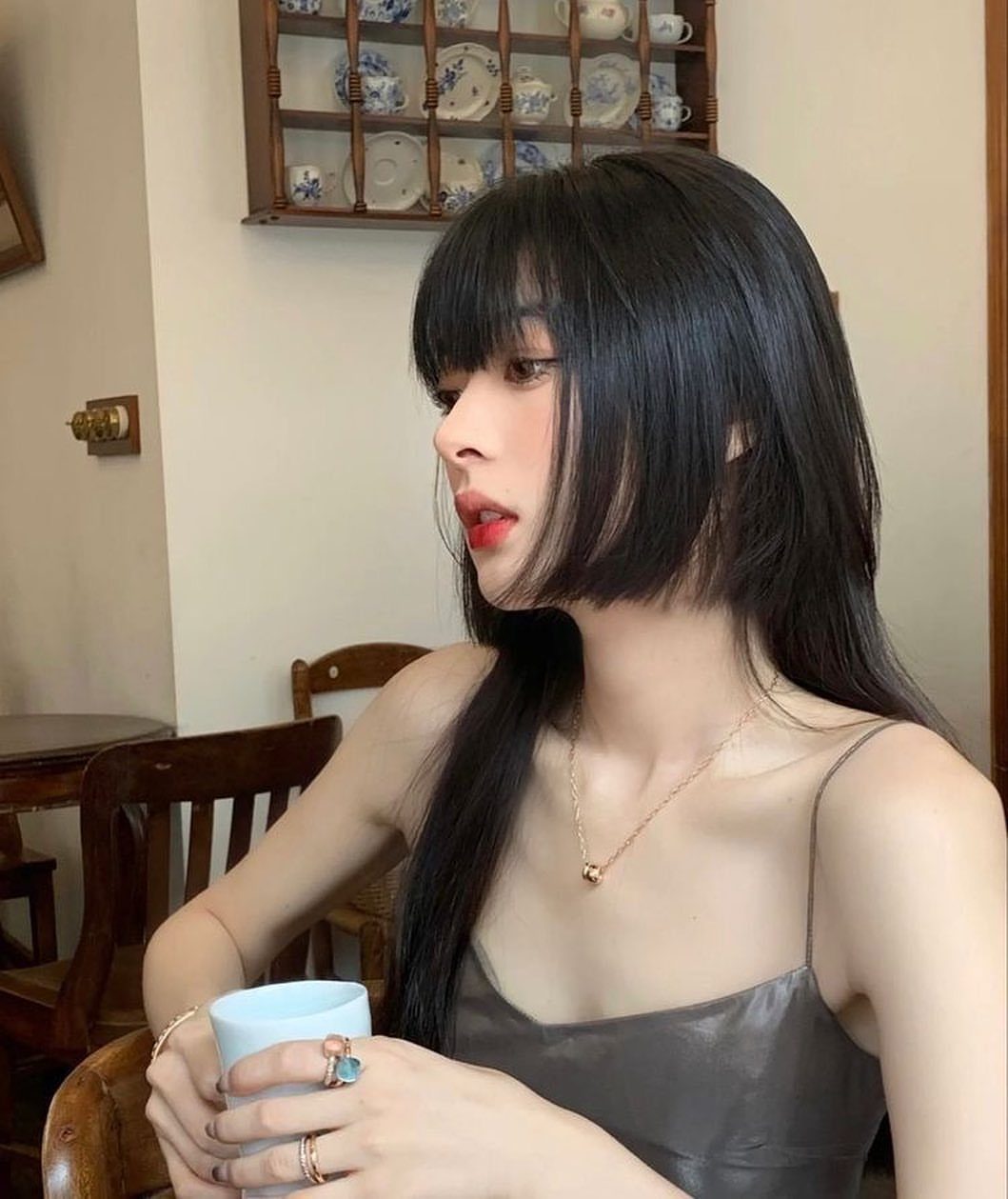 Woman with long black hime-cut hair, blunt bangs, and chin-length side sections