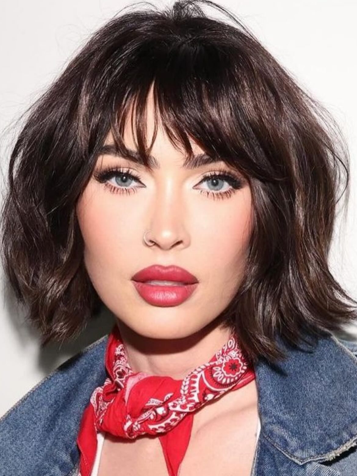 Woman with tousled chin-length dark bob, shaggy layers, and wispy bangs