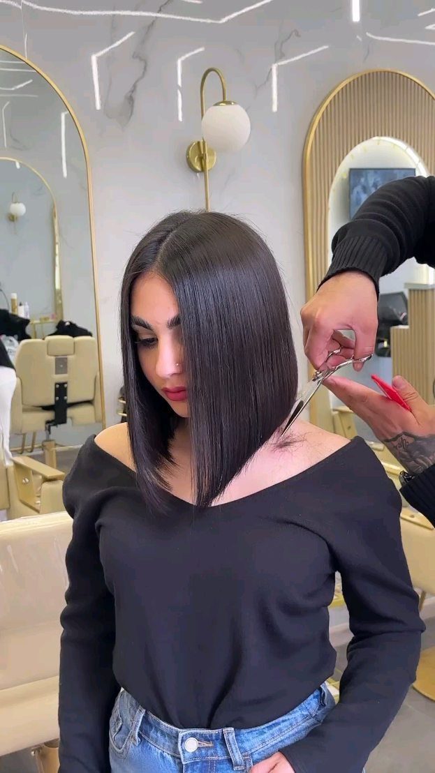 Woman getting a sleek, angled long bob trimmed in a salon