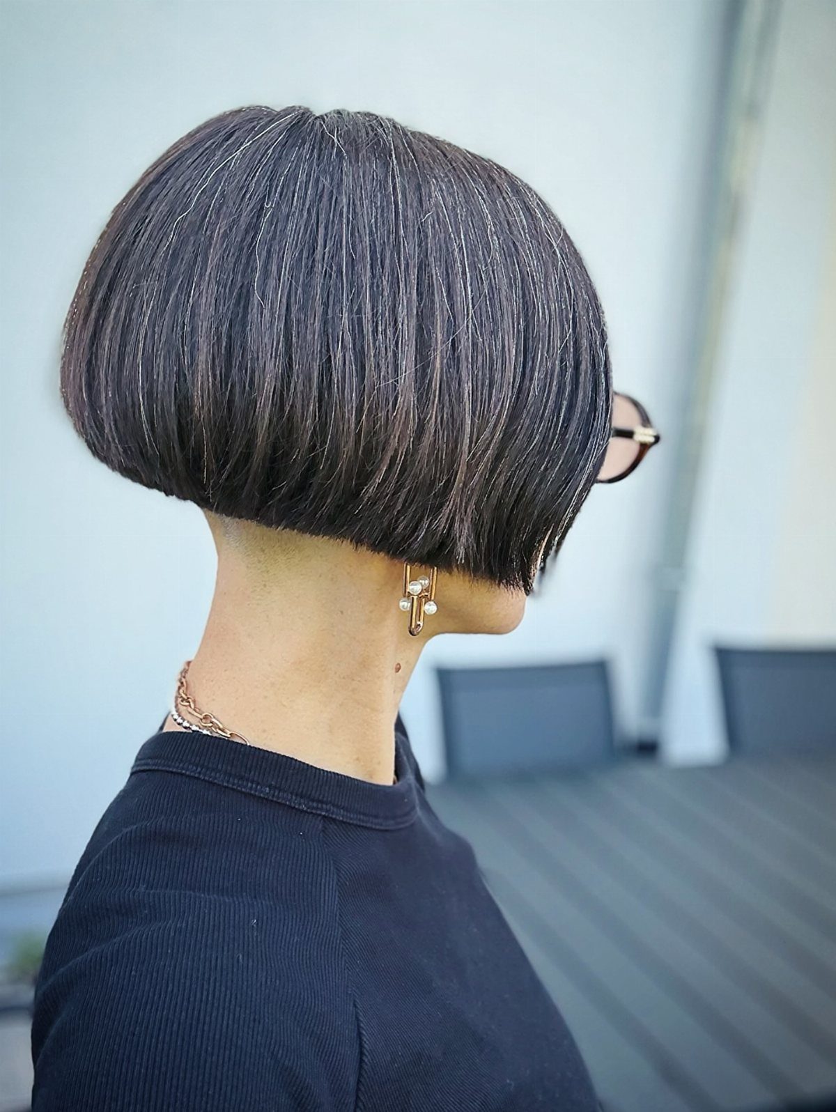 Rounded dark bob haircut with a center part, seen from the side
