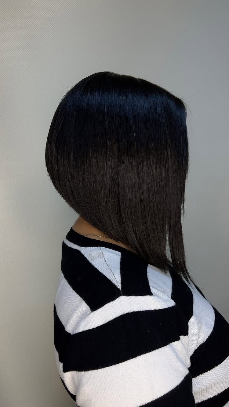Dark sleek bob haircut with a longer front section, shown in profile