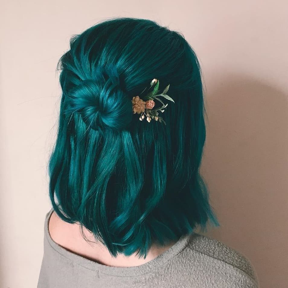Turquoise bob styled in a loose twist with a small floral hair clip
