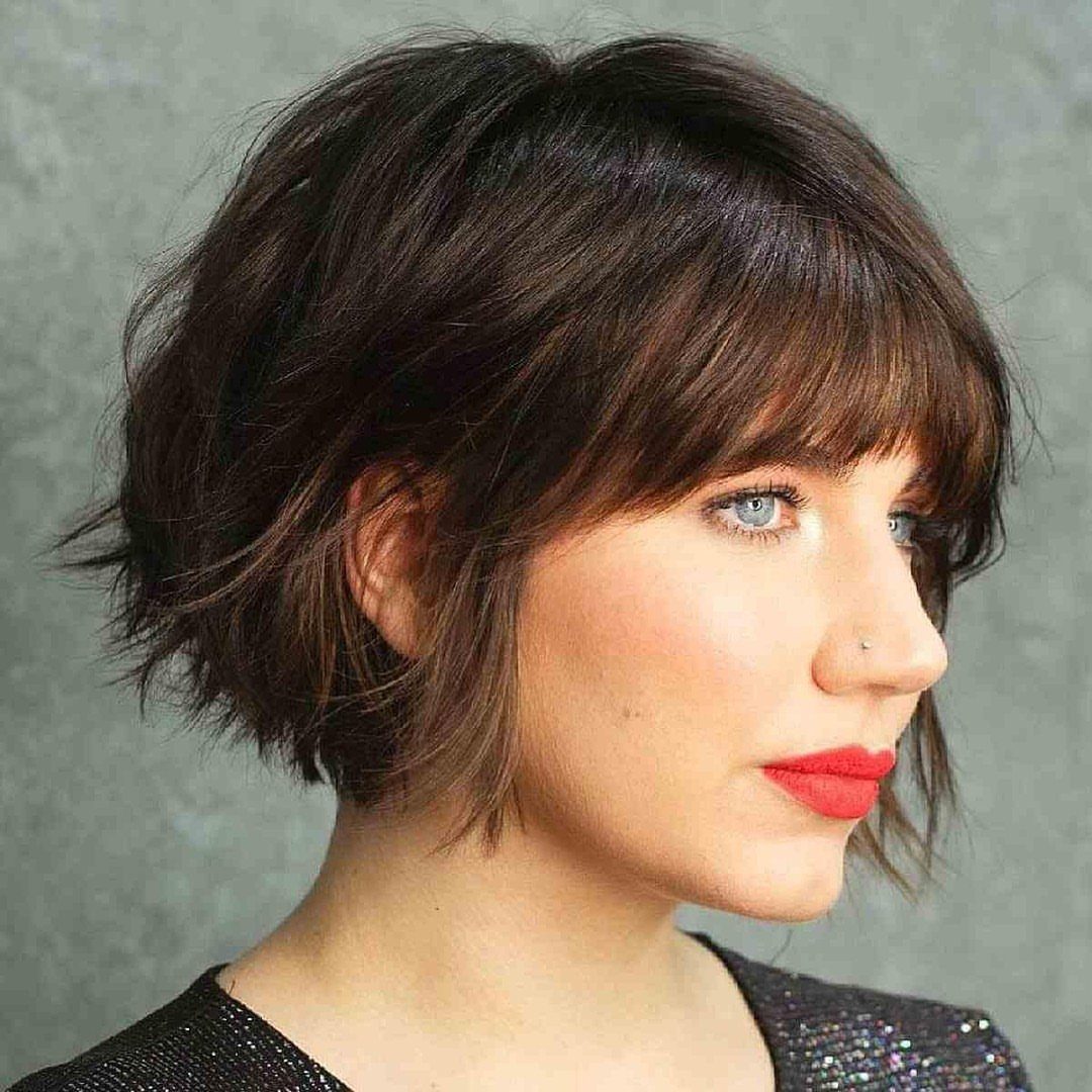 Woman showing a tousled dark choppy bob with full bangs