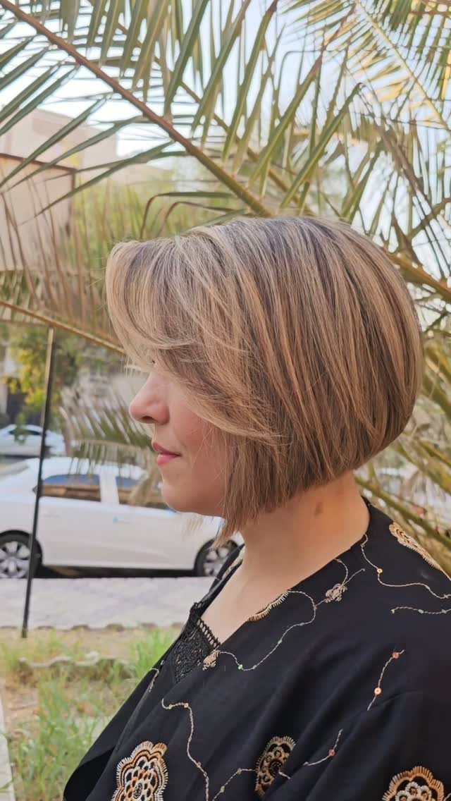 Woman showing a rounded bob haircut with sweeping bangs in side profile