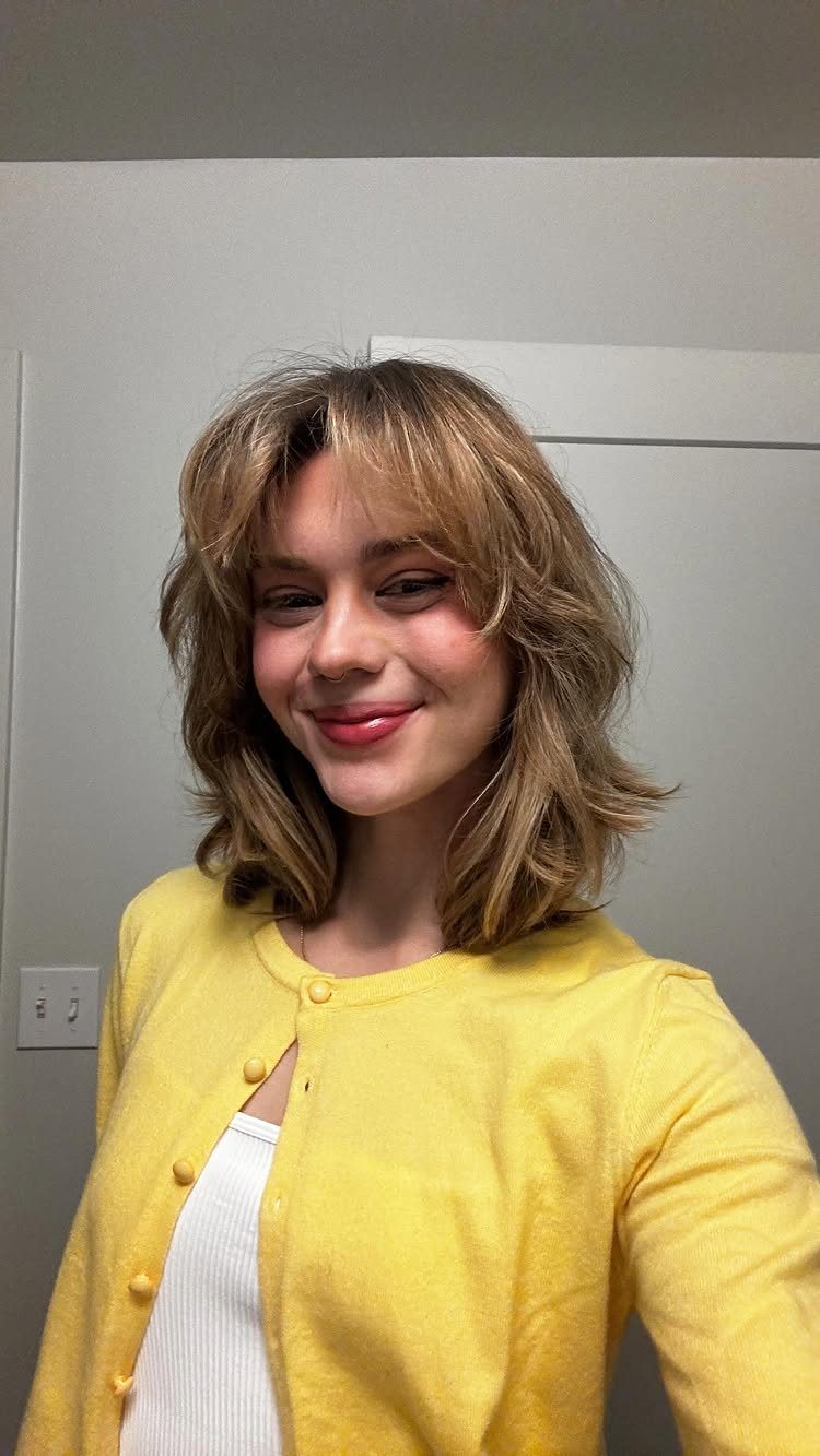 Shoulder-length blonde lob with parted fringe and softly wavy layers