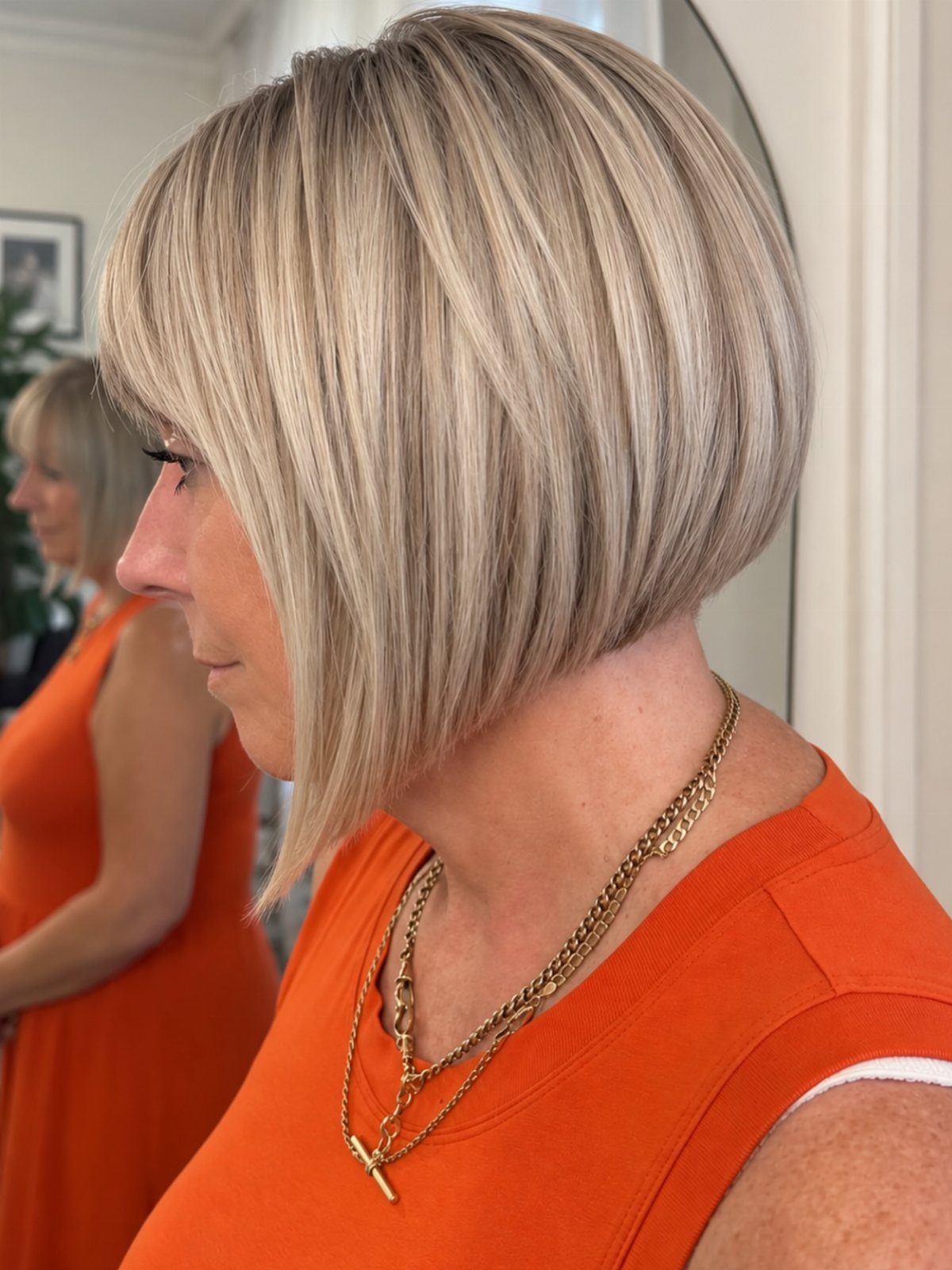 Blonde neck-length bob with long side-swept bangs and layered ends