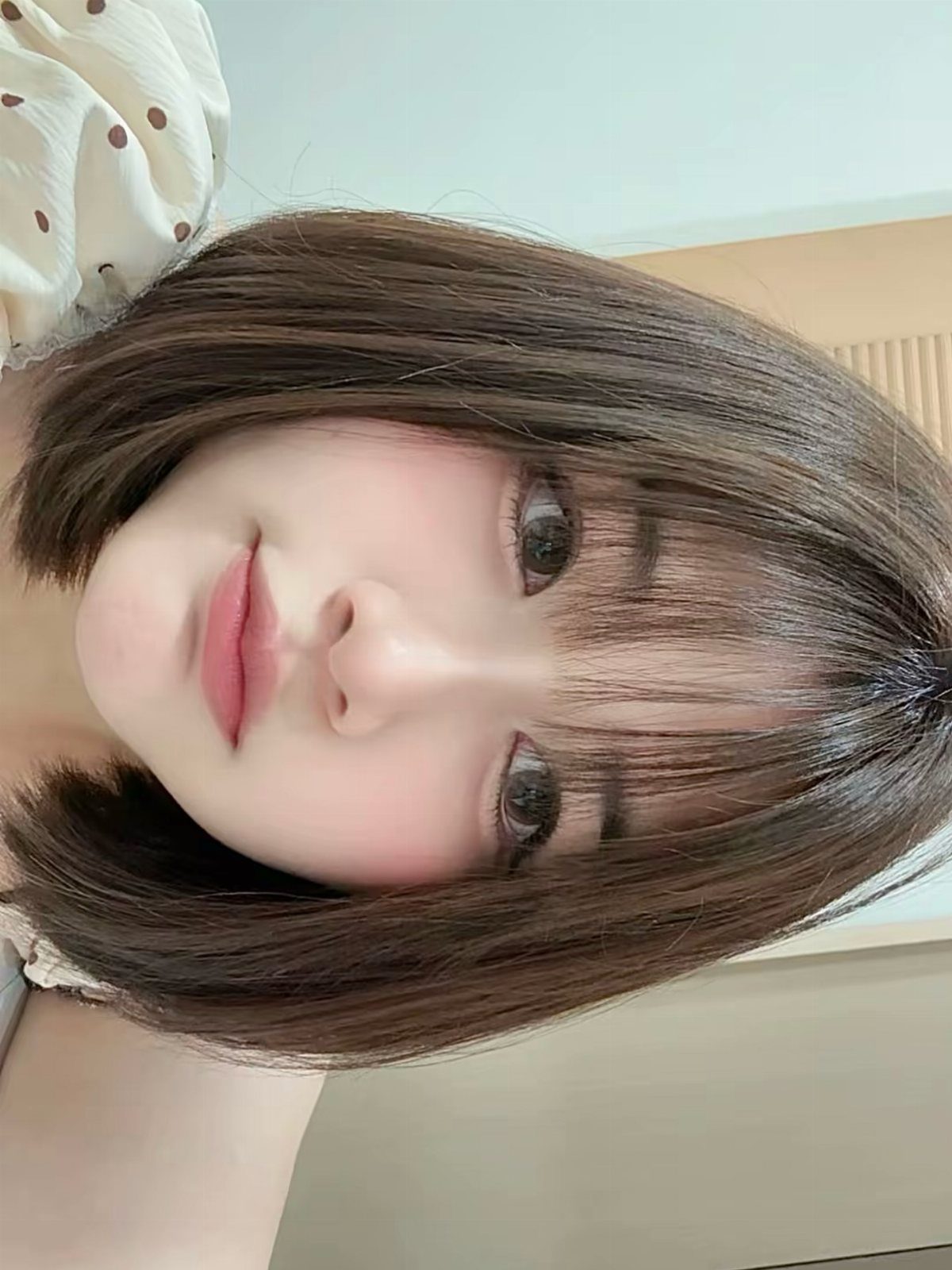 Young woman showing a smooth short brown bob with full straight bangs