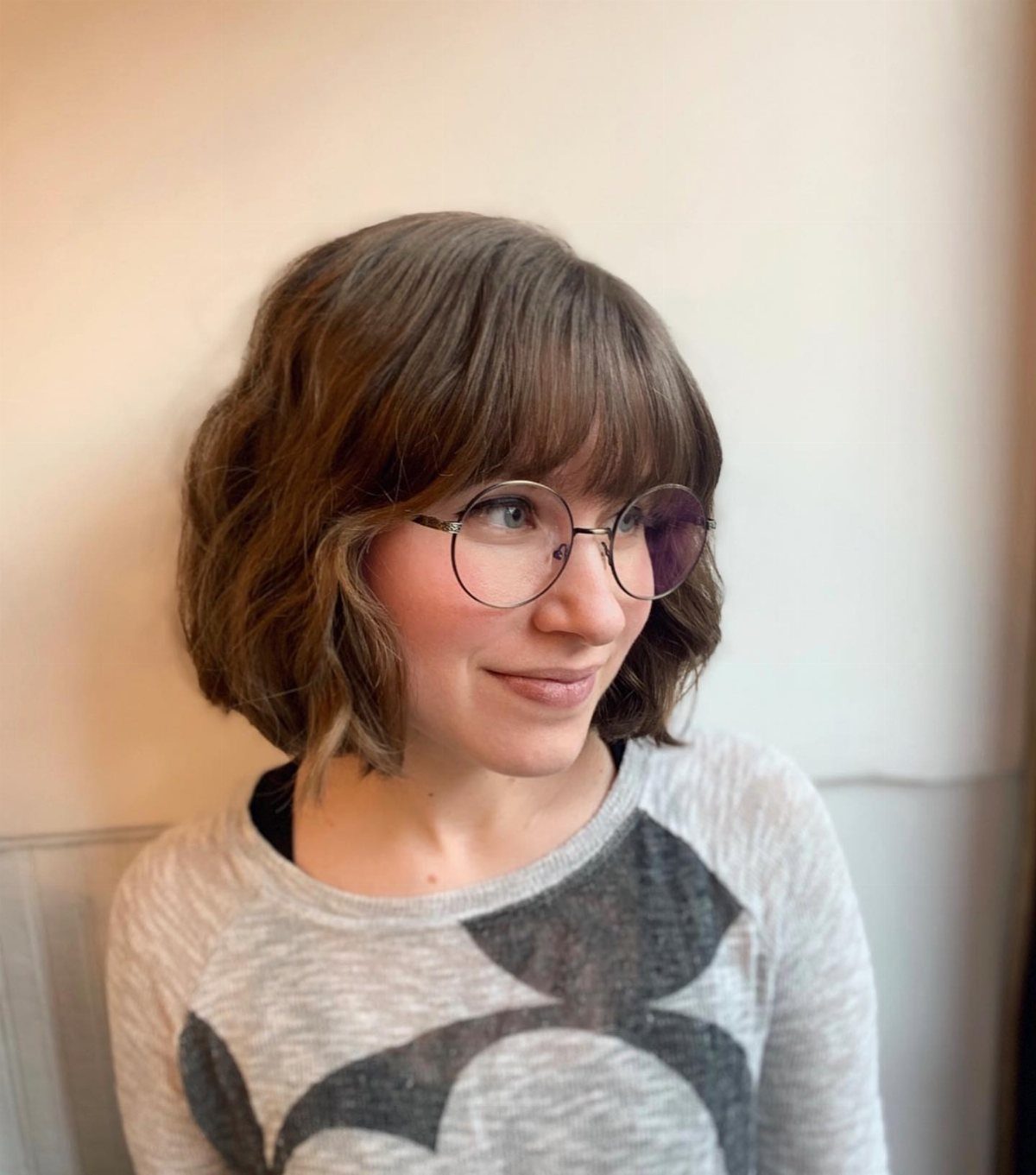 Wavy brown bob with full bangs styled around the face