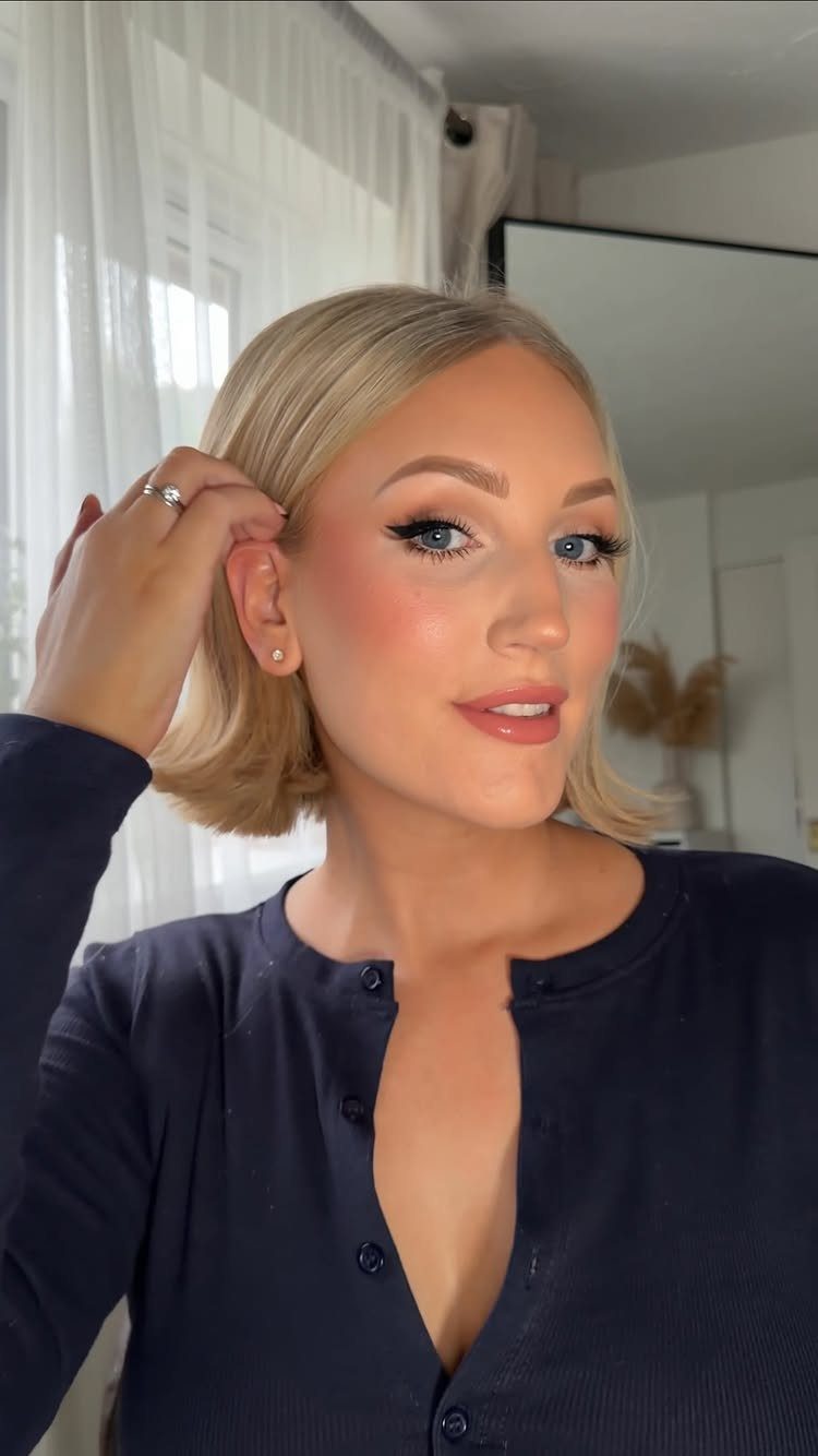 Blonde woman showing a smooth chin-length bob tucked behind one ear