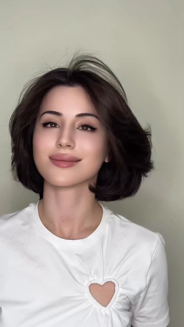 Woman with a side-parted dark bob styled in soft waves