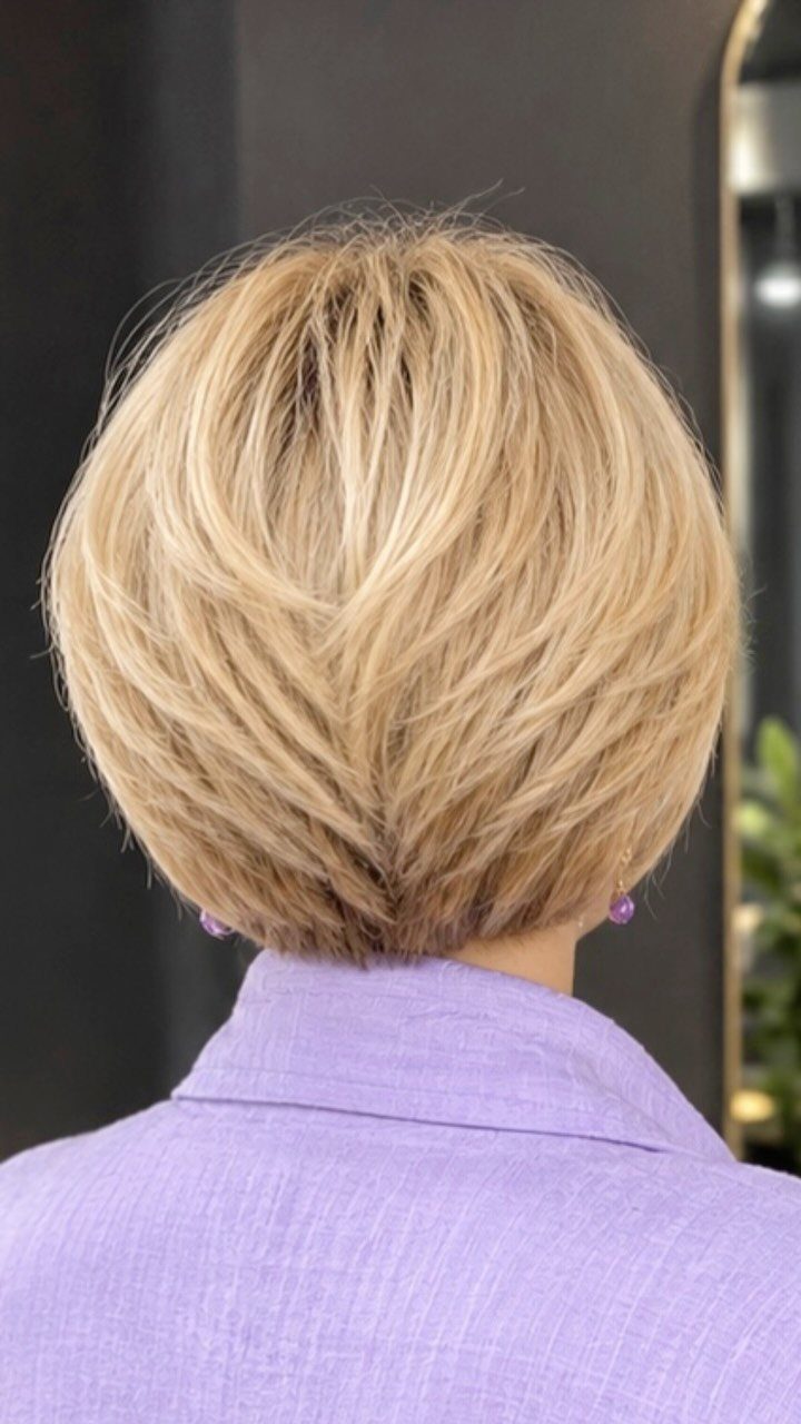 Short blonde layered bob with feathered ends viewed from behind