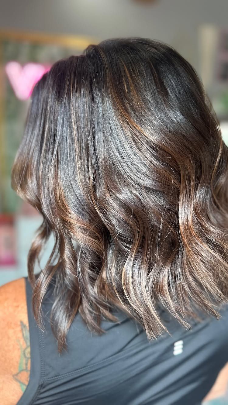 Shoulder-length highlighted hair styled in loose, layered waves