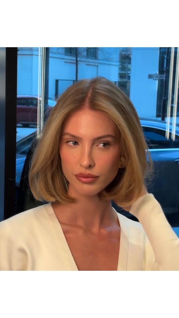 Woman with a voluminous blonde bob and softly curved-in ends