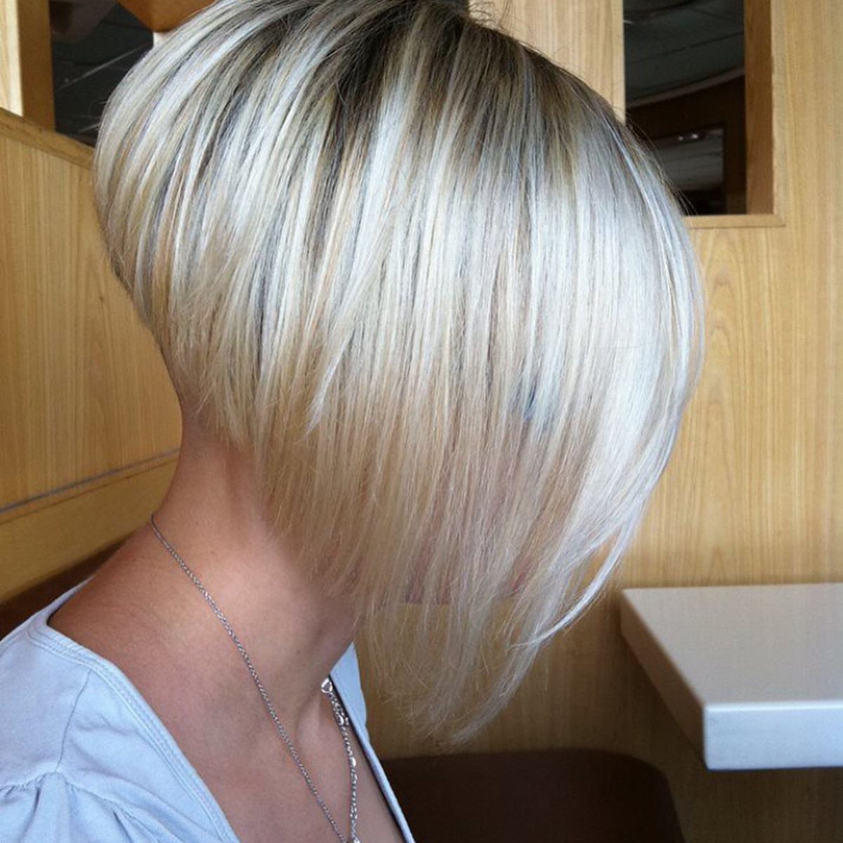 Blonde bob with dark roots and long side-swept fringe shown in profile.