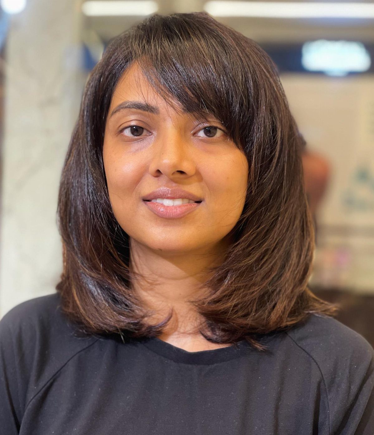 Woman wearing shoulder-length brown hair with a side-swept fringe