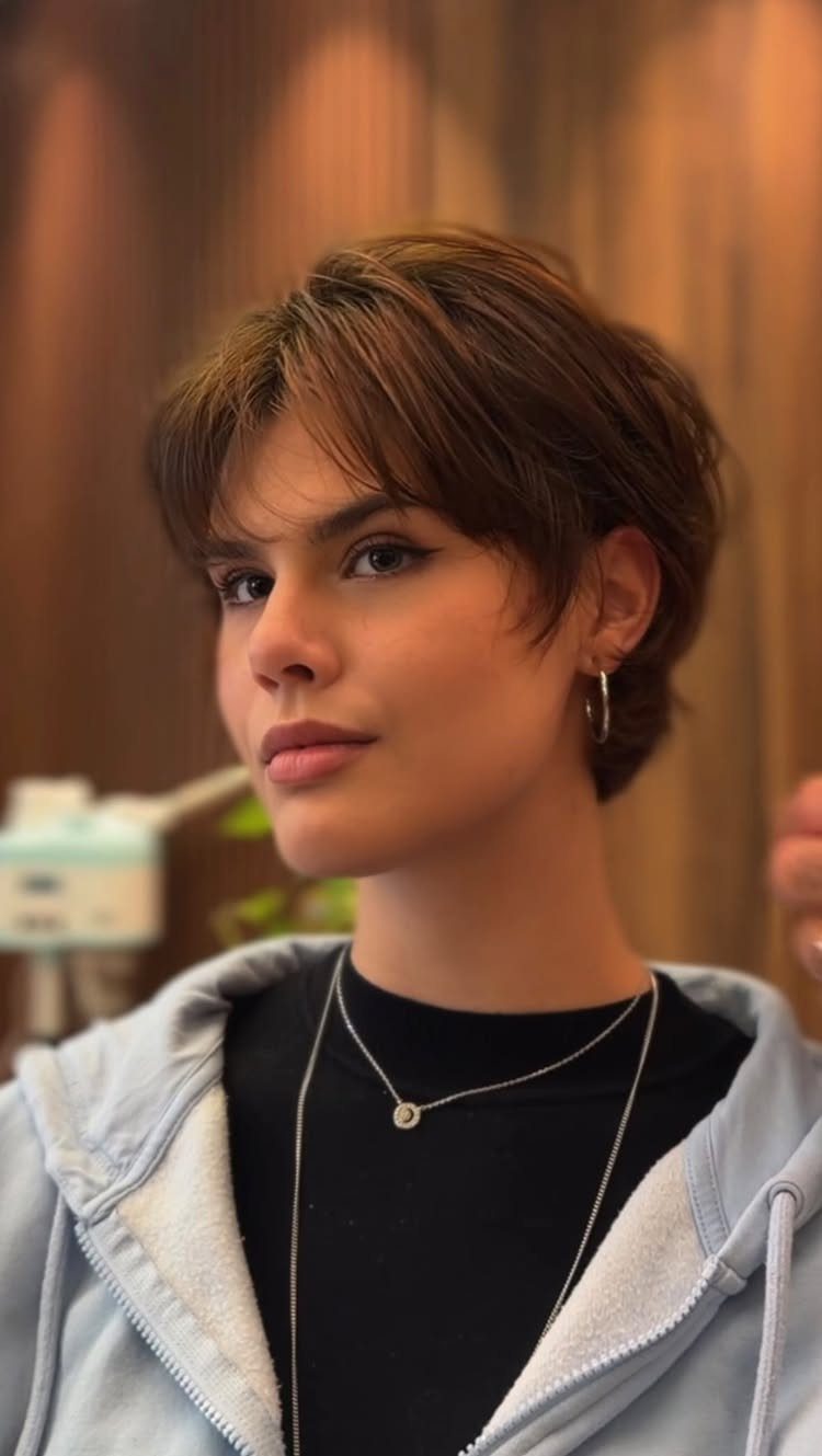 Woman with a short layered brown pixie haircut and longer tousled top