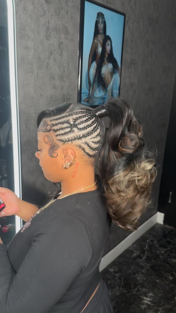 Cornrows gathered into a voluminous curly ponytail in a salon