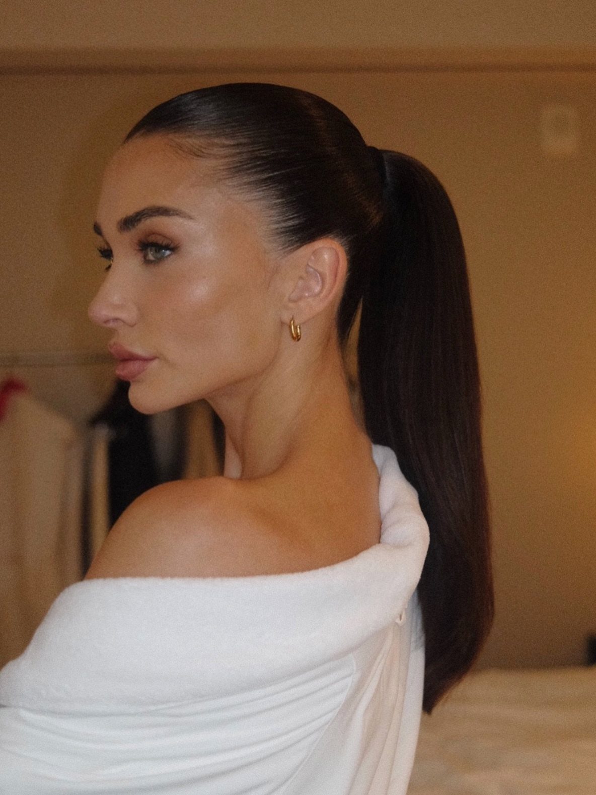 Woman with long, sleek straight hair tied in a high ponytail