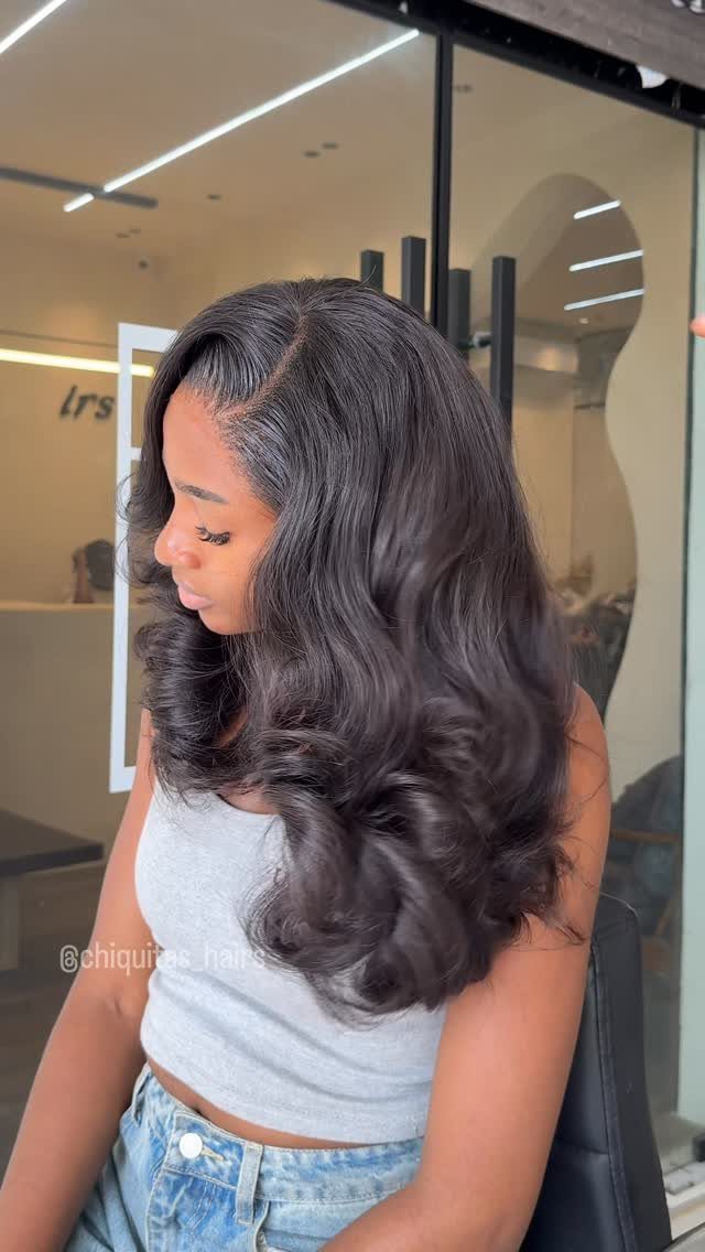Long dark hair styled in voluminous waves with curled ends