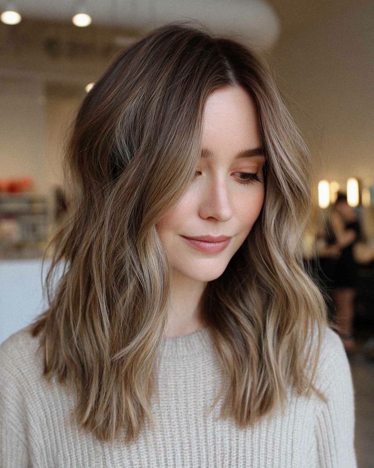 Long brown hair falls in relaxed waves with loose face-framing strands