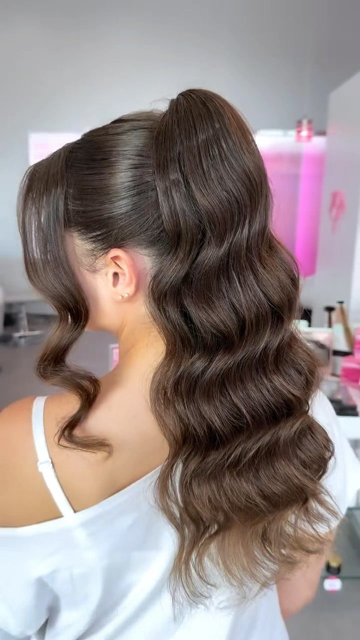 High wavy ponytail with long glossy brown hair in a salon