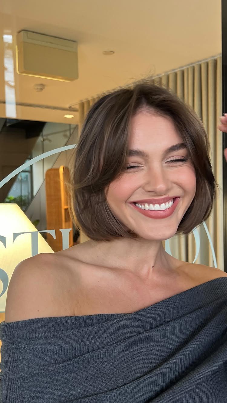 Woman showcasing a sleek blunt bob with softly layered ends indoors