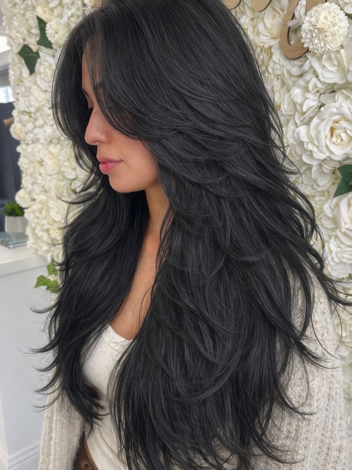 Long dark hair with feathered layers flowing outward at the ends