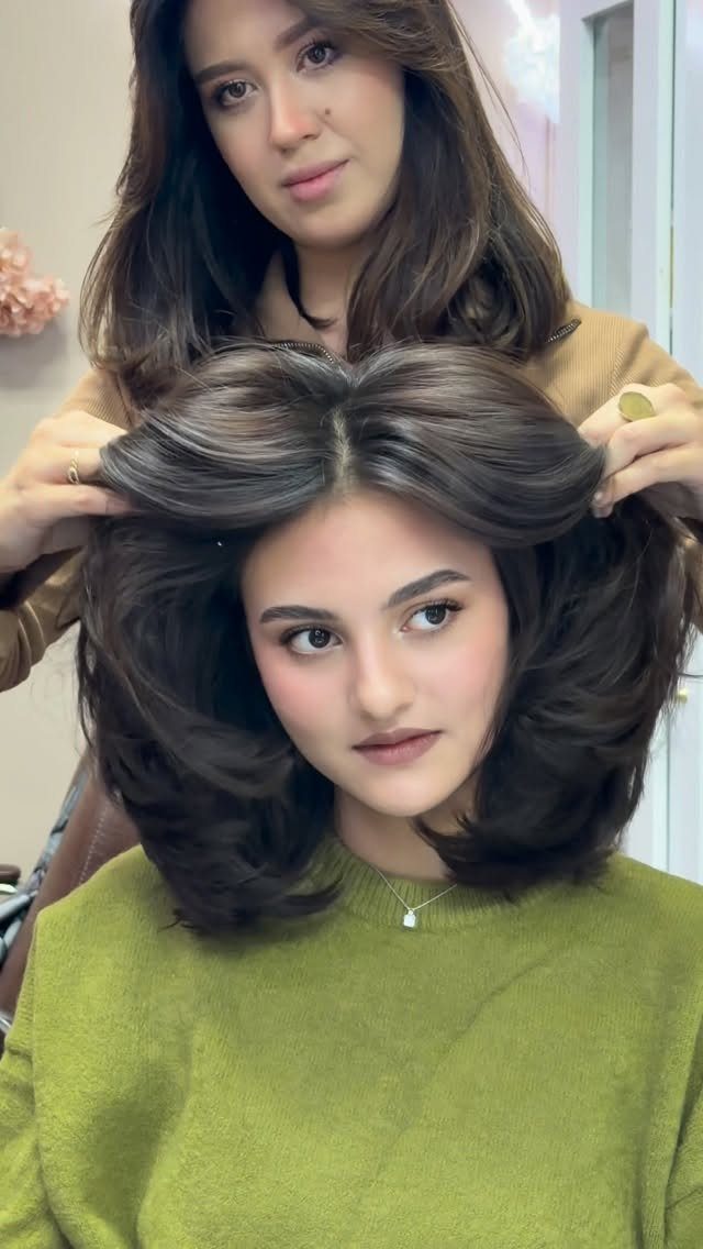 Women showing a voluminous layered hairstyle in a salon