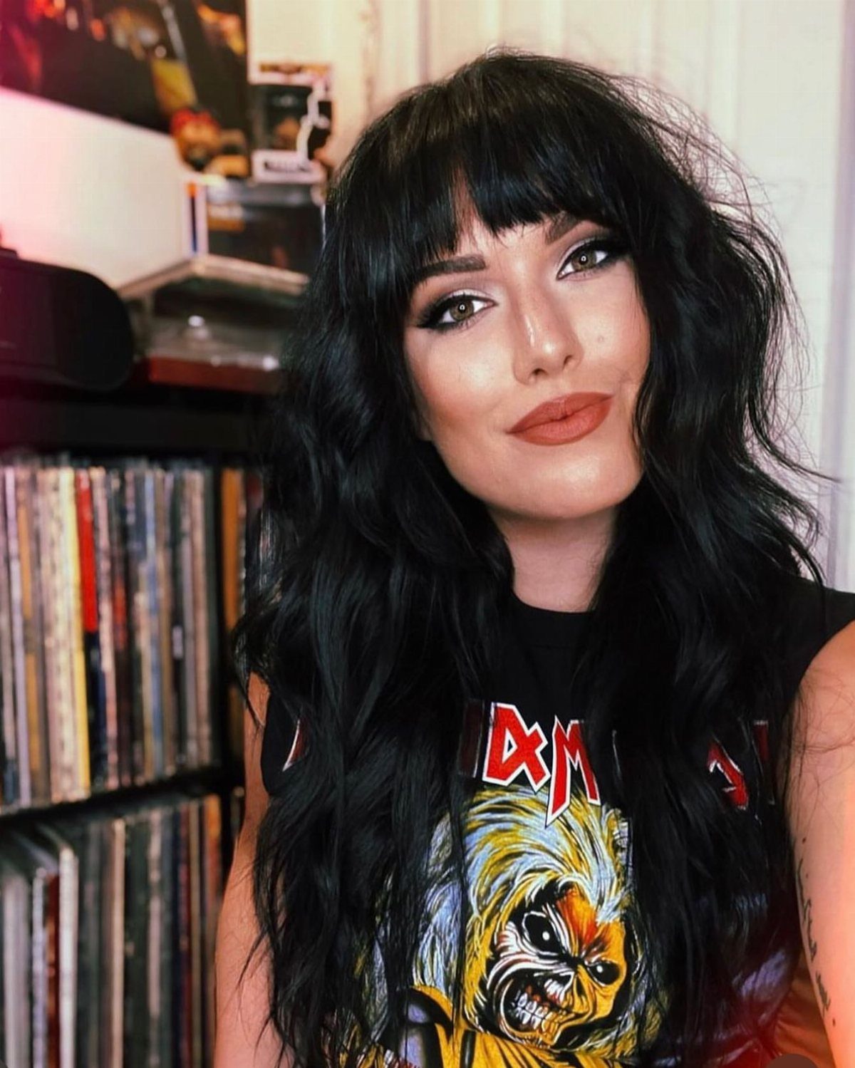 Woman with long black waves and a dense, choppy squared fringe