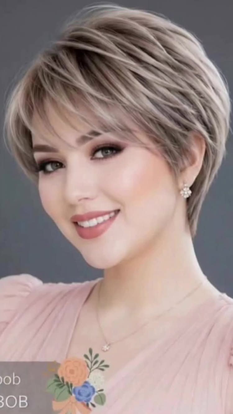 Woman showing a short layered blonde bob with side-swept bangs