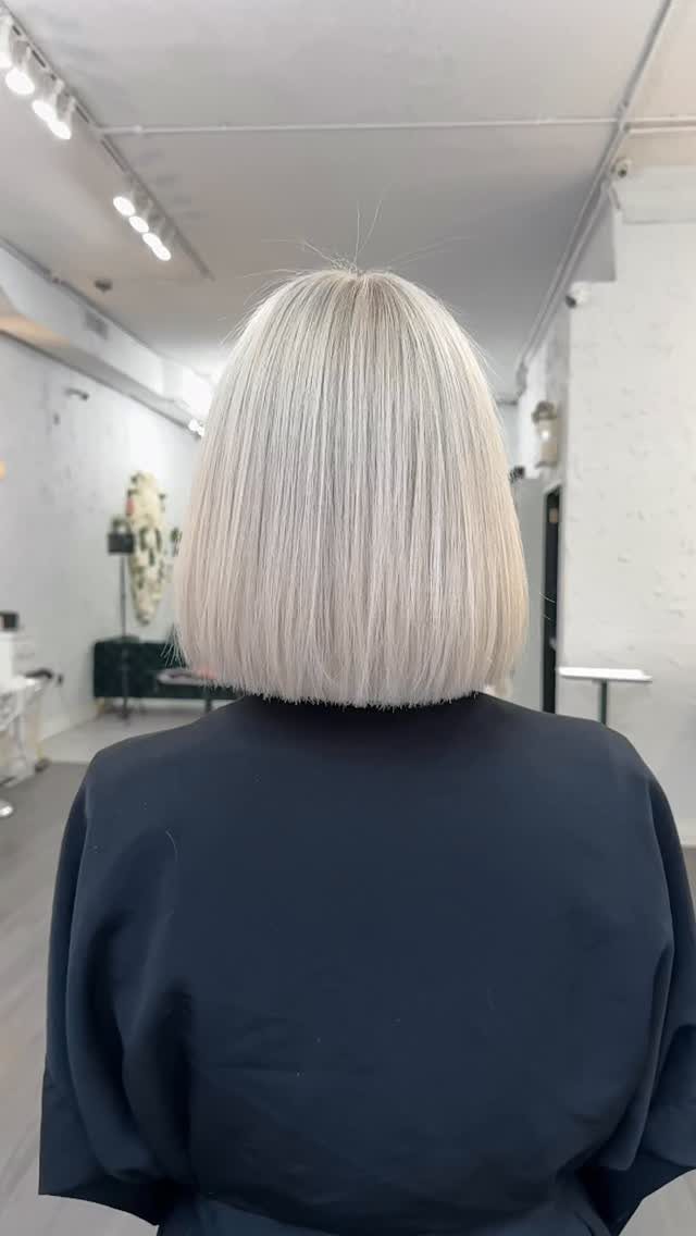 Blonde straight bob with a blunt, rounded edge in a salon
