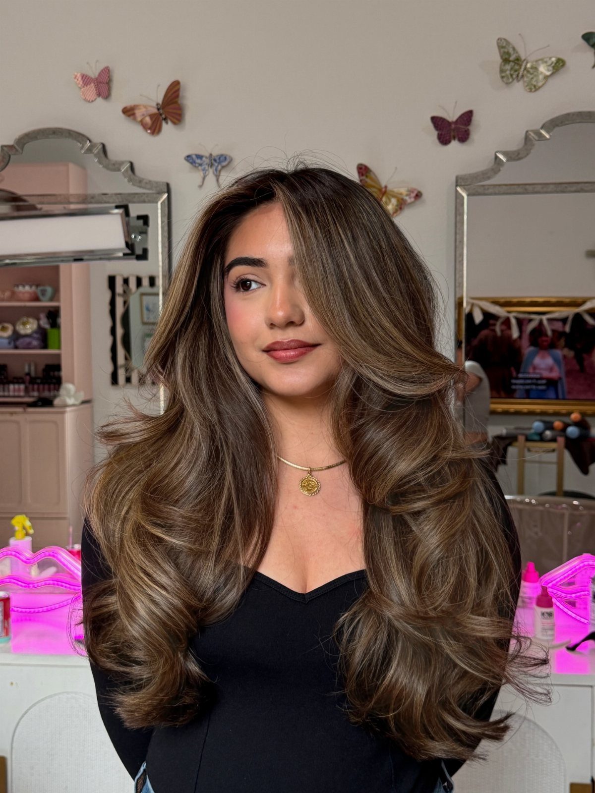 Woman showing a golden-brown layered blowout with outward-curled ends