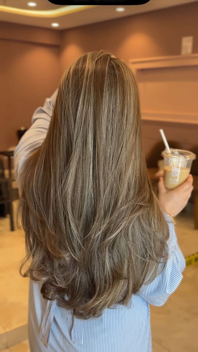 Mid-back brown hair with subtle lowlights and softly curled ends