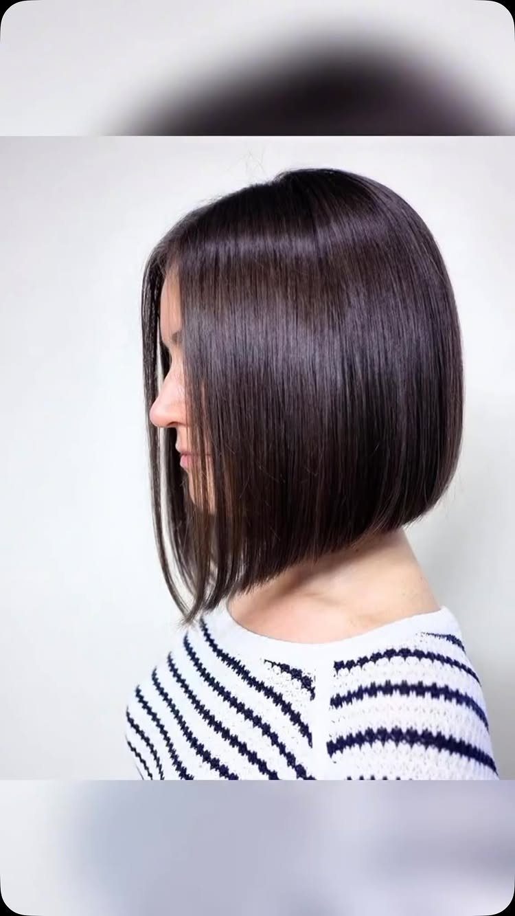 Angled dark bob frames a woman's face, longer in front and shorter at the back