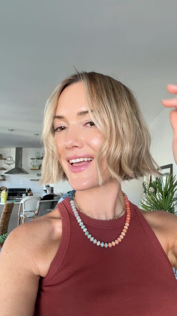 Woman with a soft, wavy chin-length blonde bob and center part