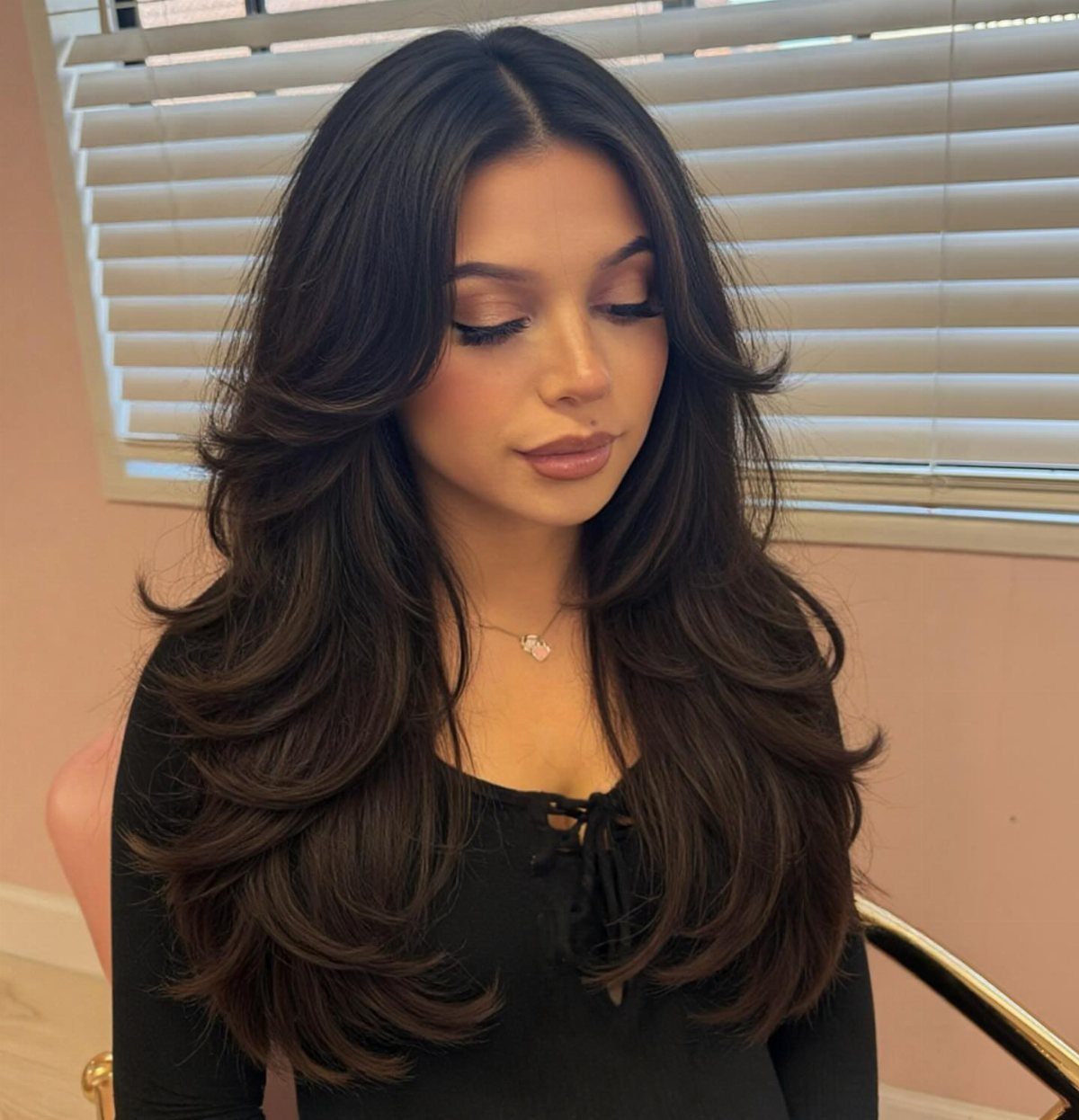 Woman with long dark hair styled in loose, flowing waves