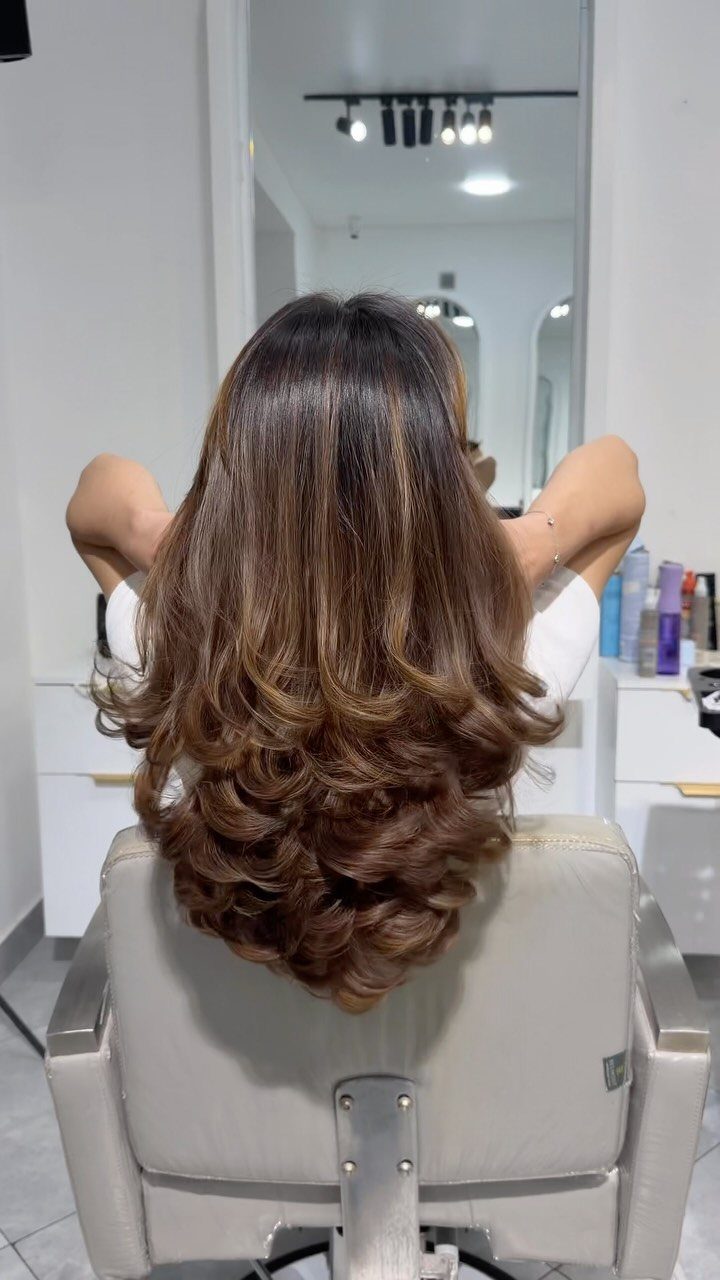 Long brown hair styled in a voluminous, bouncy salon blowout