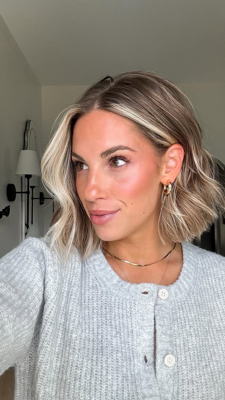 Woman showing a choppy, shoulder-length lob with a deep side part and tousled waves