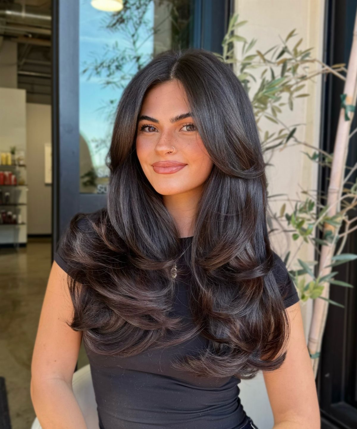 Woman with long dark hair in voluminous, softly curved layers