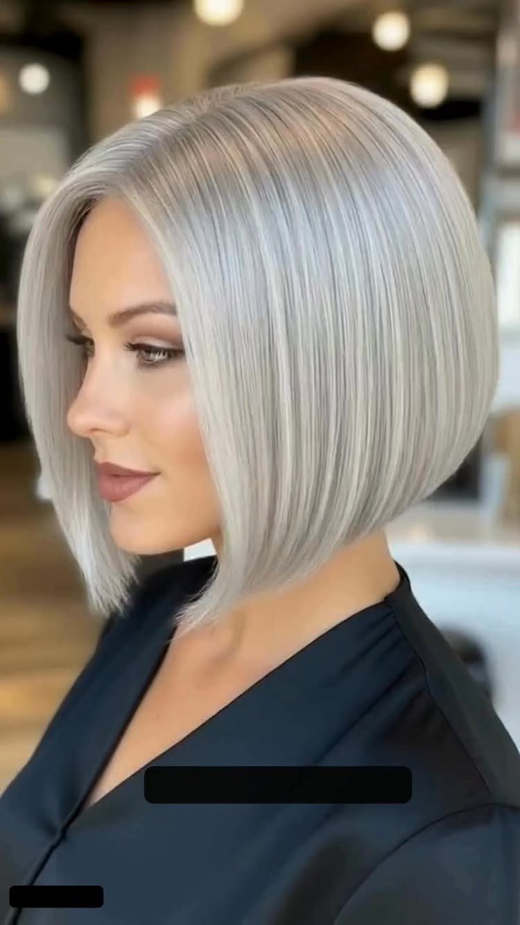 Woman modeling a sleek silver-gray angled bob with a side part