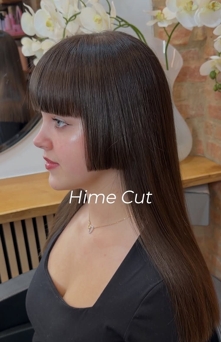 Woman in a salon showing a long, straight Hime cut with blunt bangs