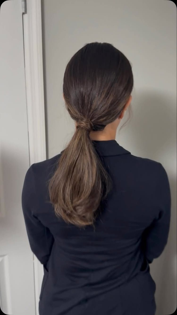Smooth brown hair gathered into a polished low ponytail at the nape