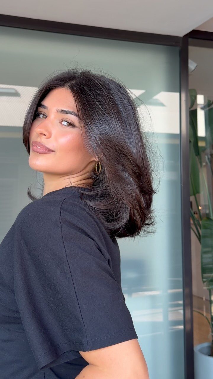 Woman showing a shoulder-length straight haircut with layered, flipped-out ends