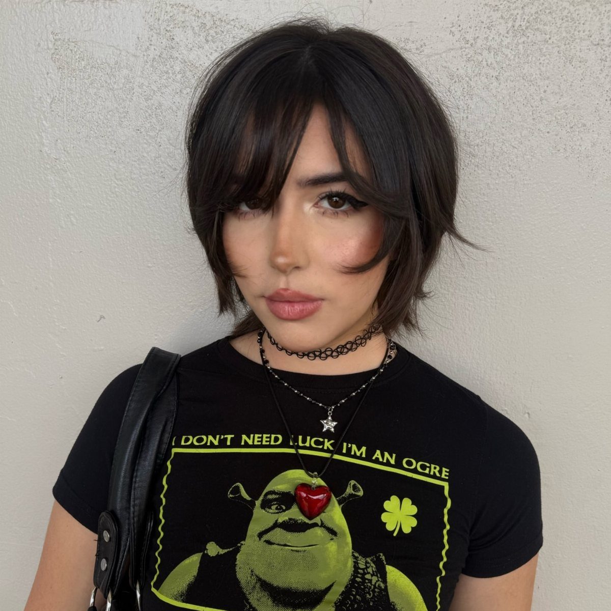 Short dark bixie haircut with voluminous layers and side-swept bangs