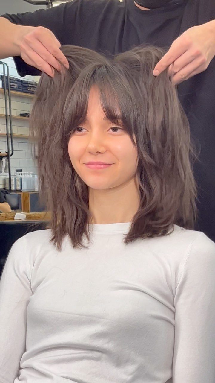 Shoulder-length shaggy brown hair with wispy bangs in a salon