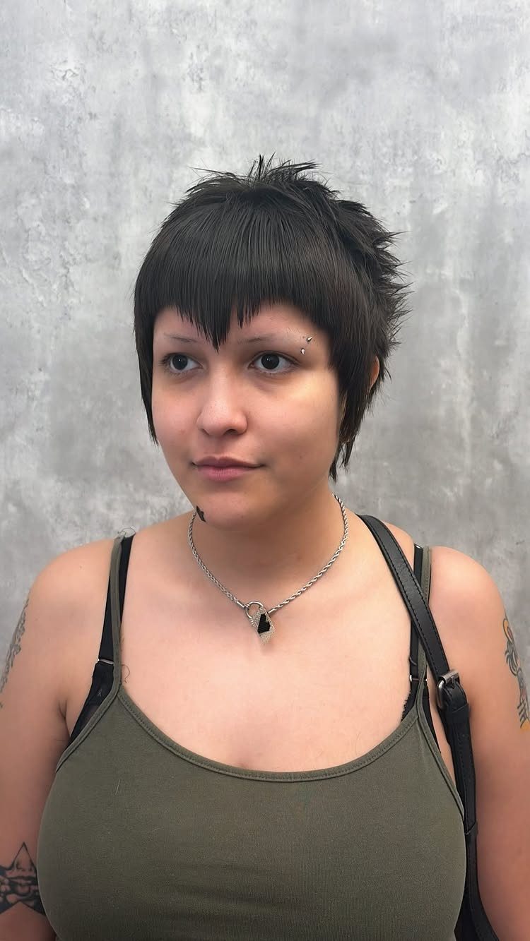 Person with short dark hair and a pointed V-shaped fringe